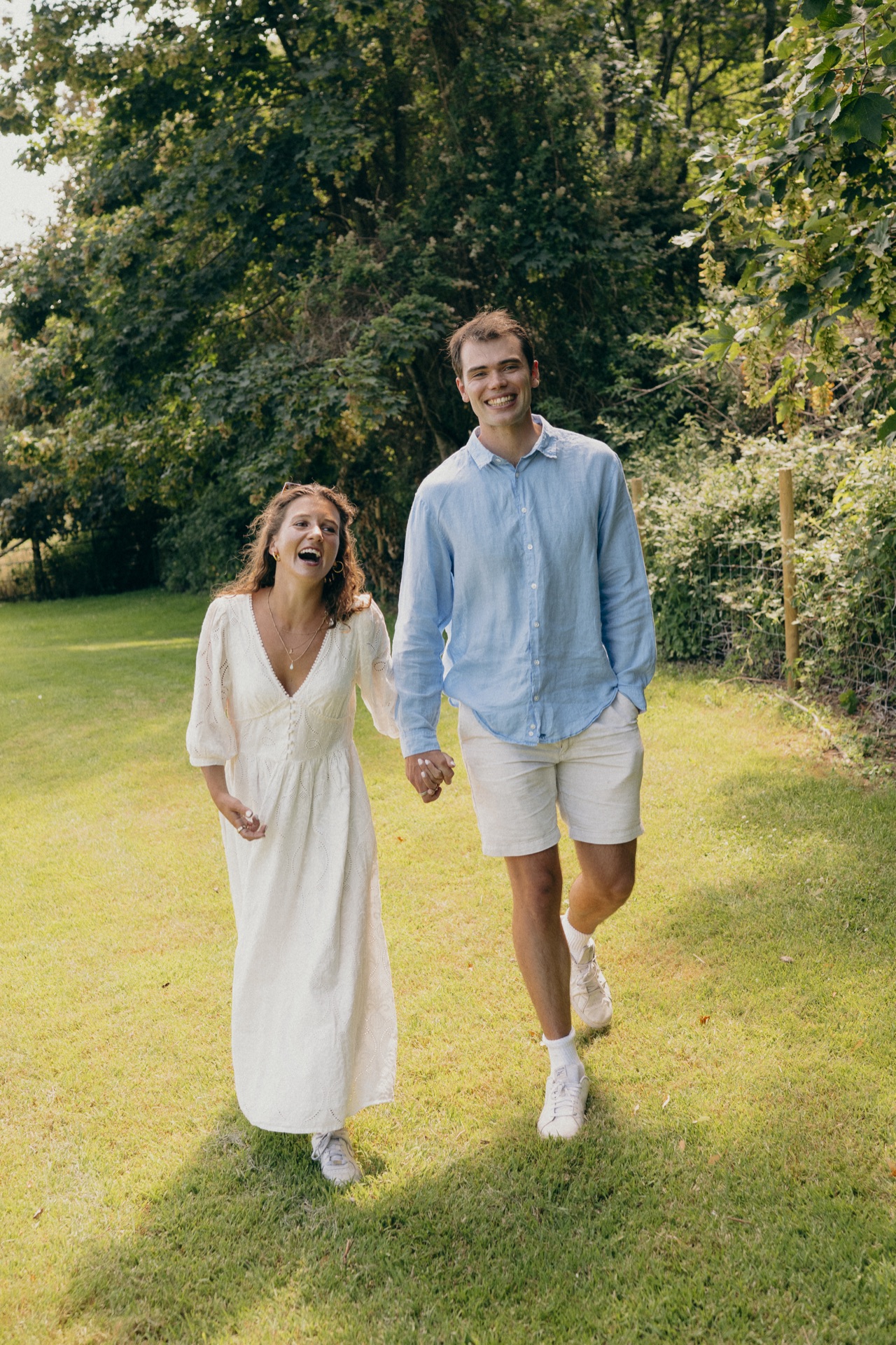 Vere and Ella walking hand in hand across a summer field
